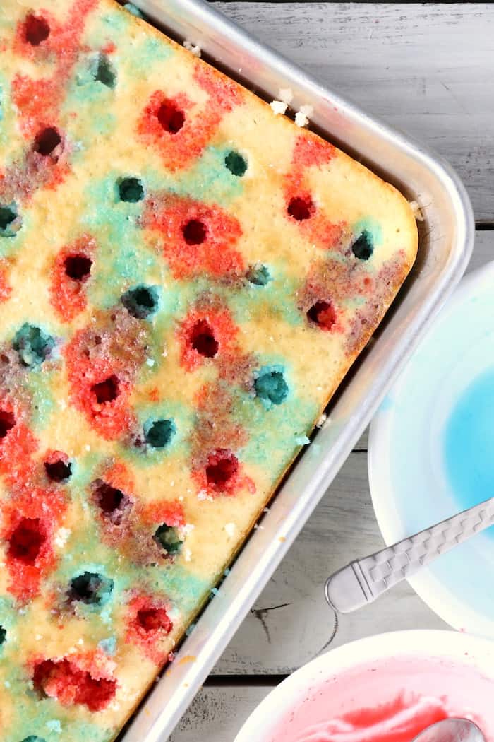 Show your American pride with this Patriotic Jello Poke Cake! Moist, delicious cake drizzled with sweet, colorful jello, all covered with whipped topping! #InspirationalMomma #jellopokecake #pokecake #America #4thofJuly #jello #cake #dessert #desserts #recipe #patriotic #redwhiteblue
