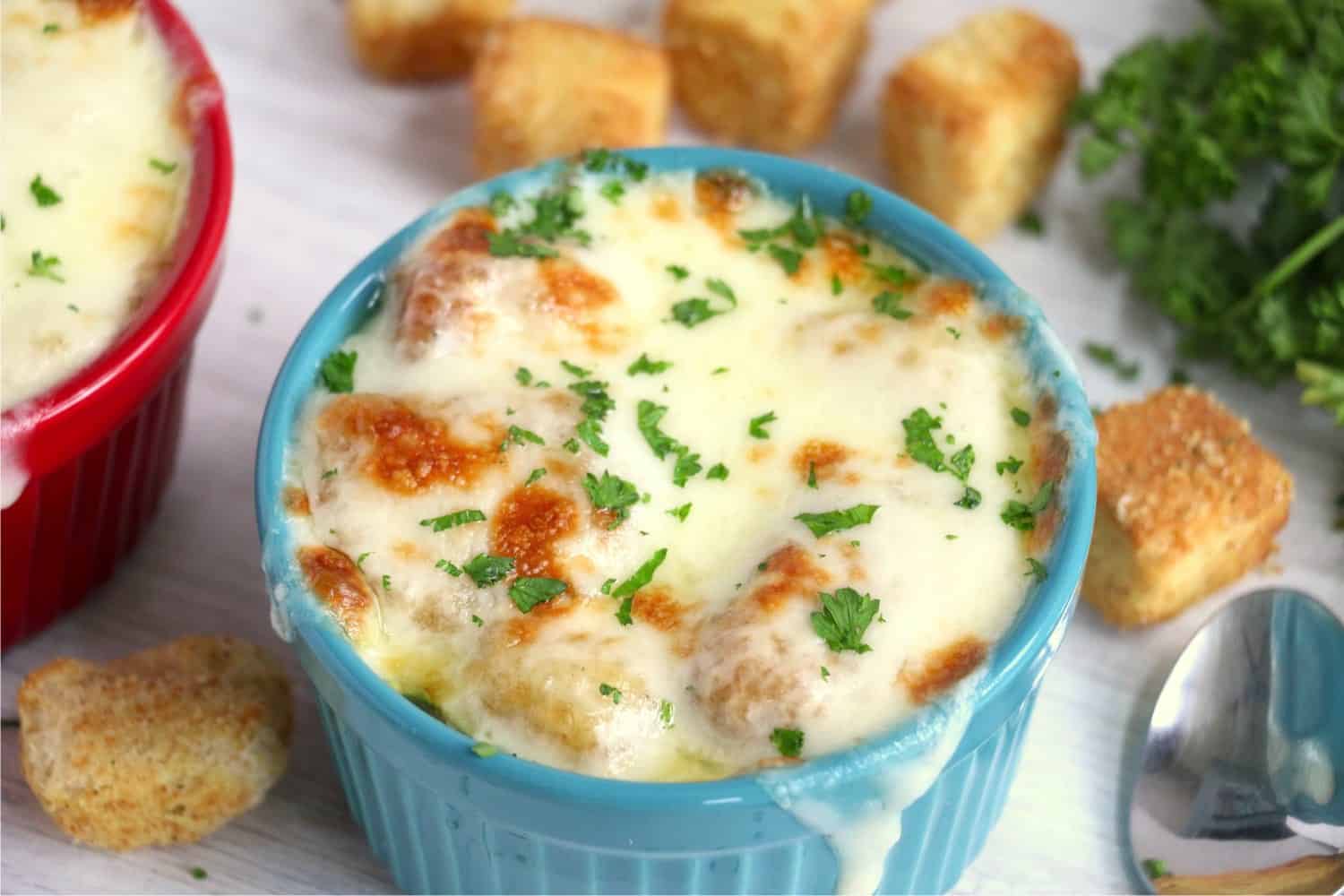 Bowl filled with soup surrounded by croutons.