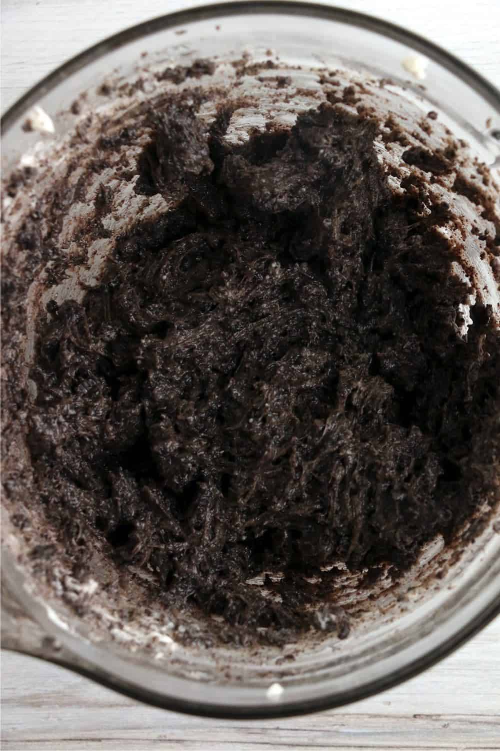 Oreos and cream cheese mixed together in a mixing bowl.