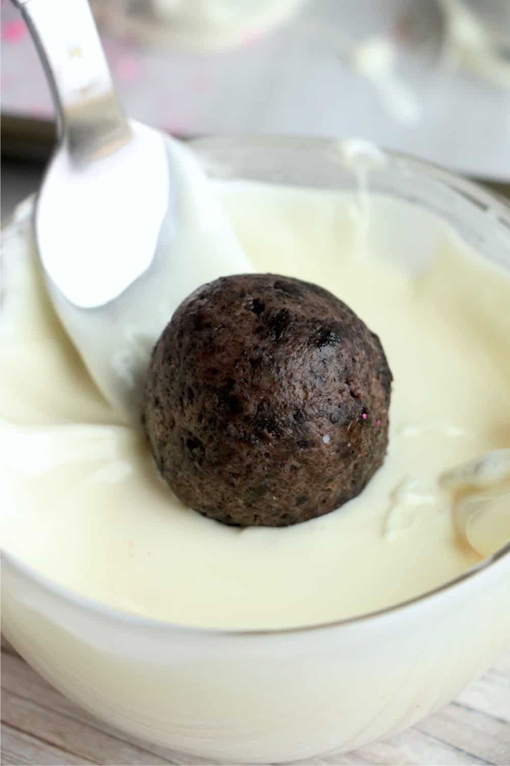 Truffle being dipped into melted white bark.