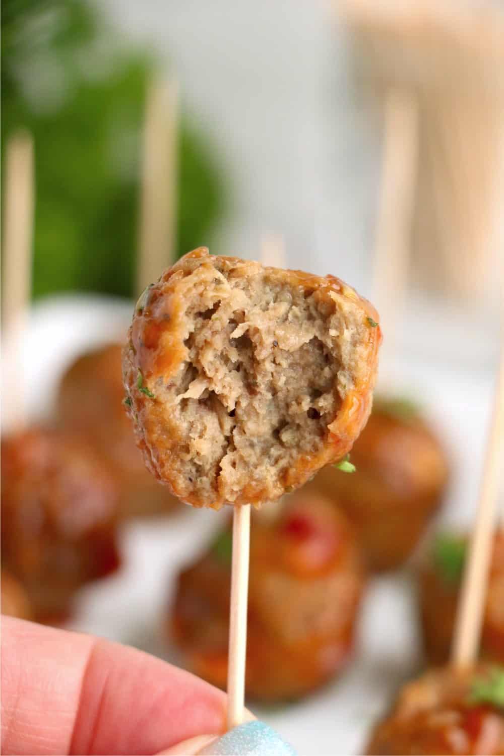 Crock Pot Honey Garlic Meatball on a toothpick with a bit taken out.