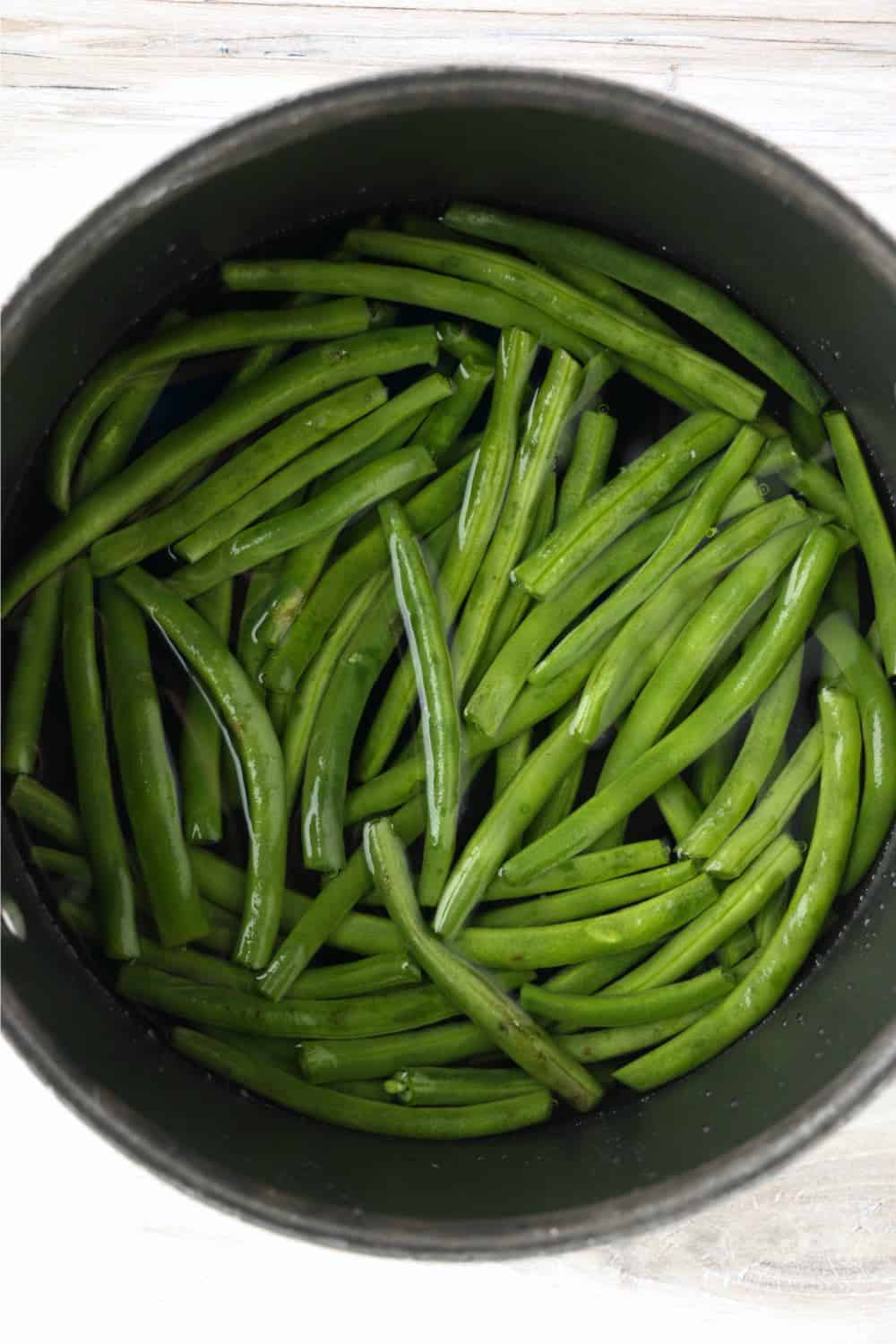 Green beans in water, cooking in a pot on the stove