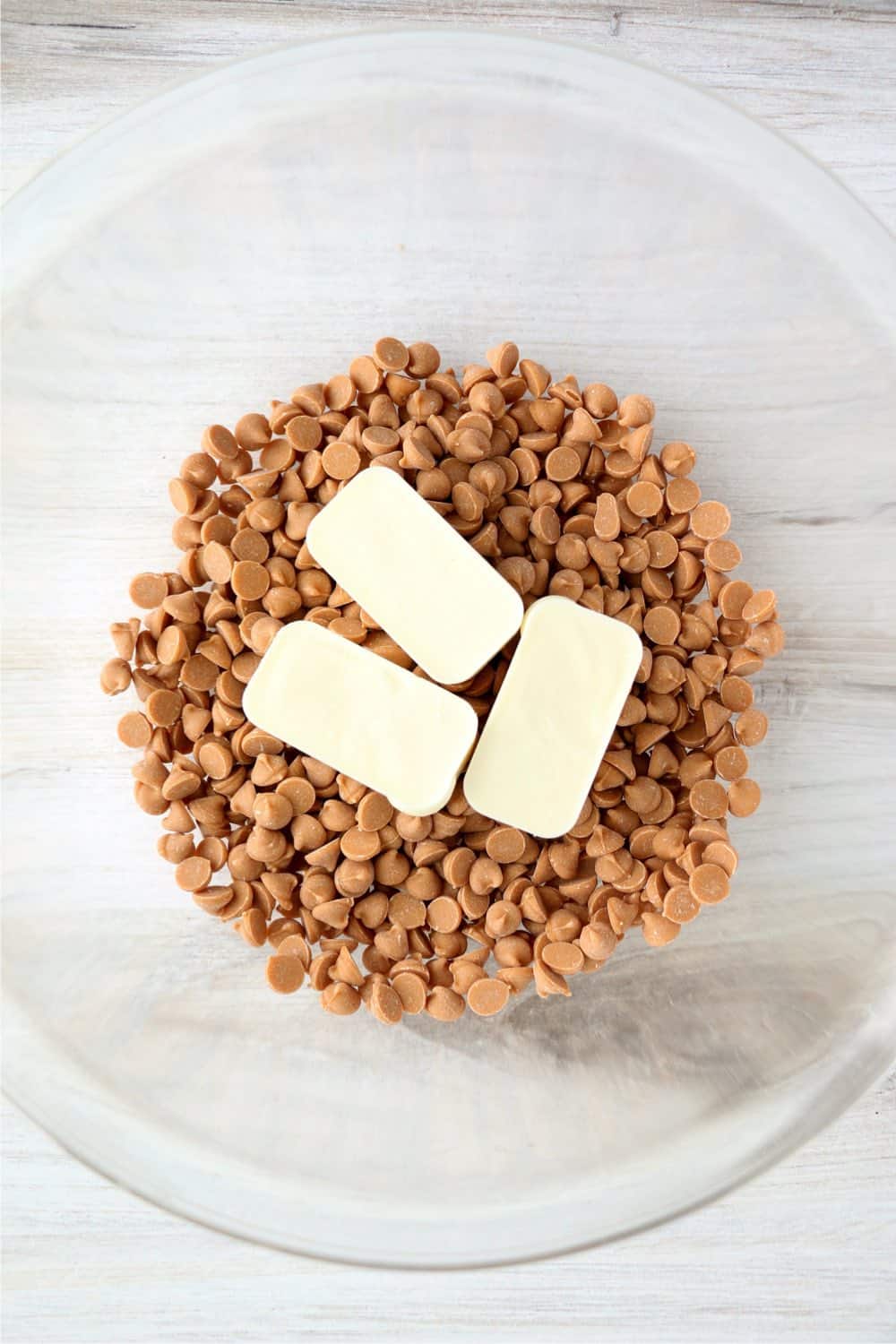 Butterscotch chips and white bark in a clear glass bowl