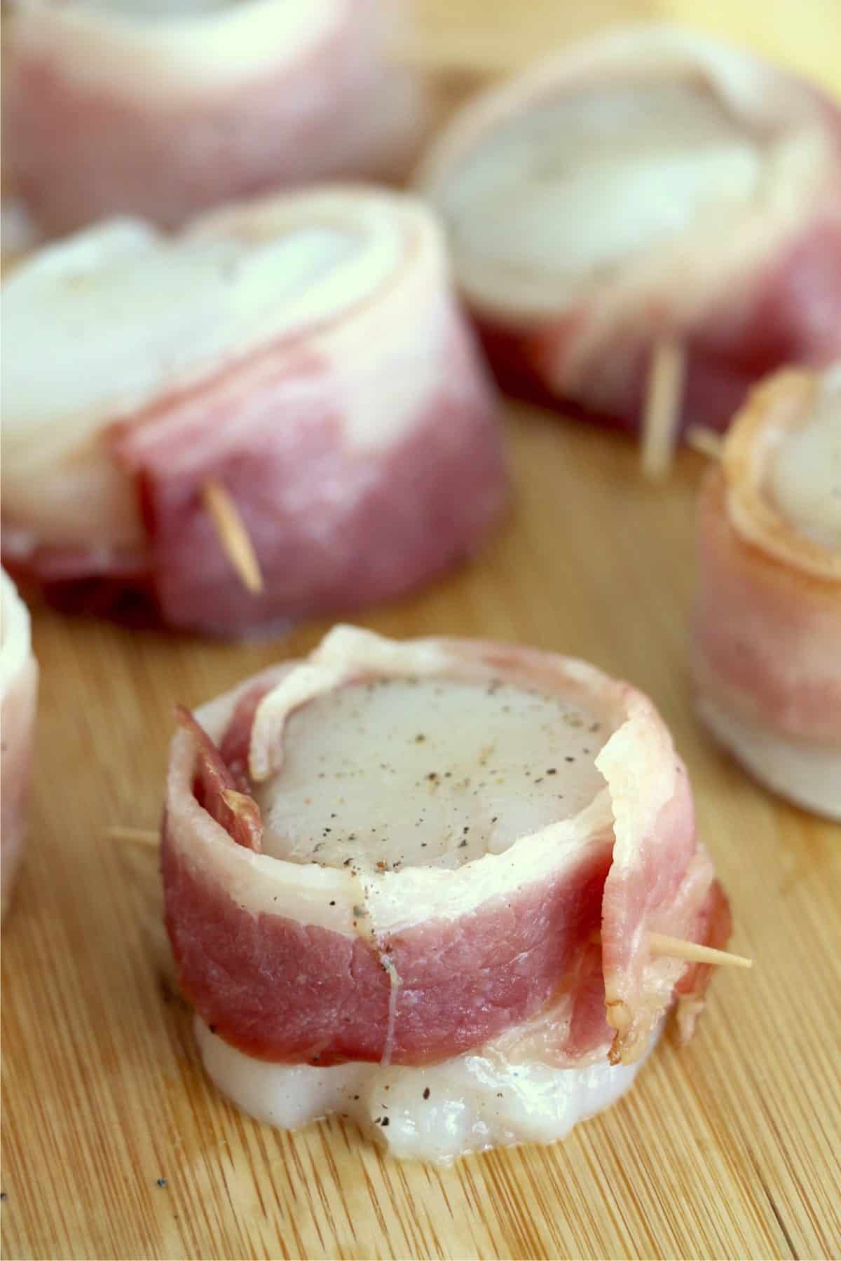 Raw bacon wrapped scallops skewered with toothpicks