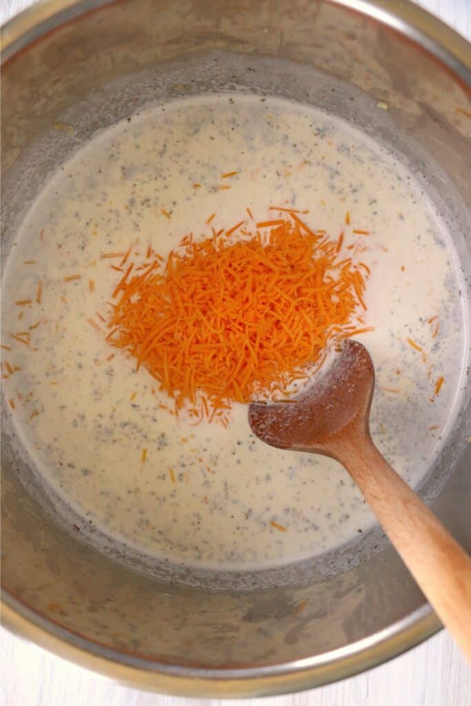 Overhead shot of cheese being stirred into sauce