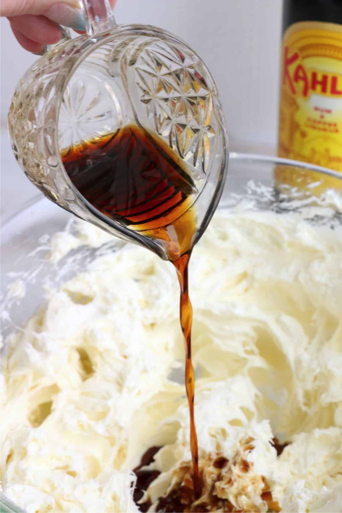Kahlua being poured into creamed cream cheese