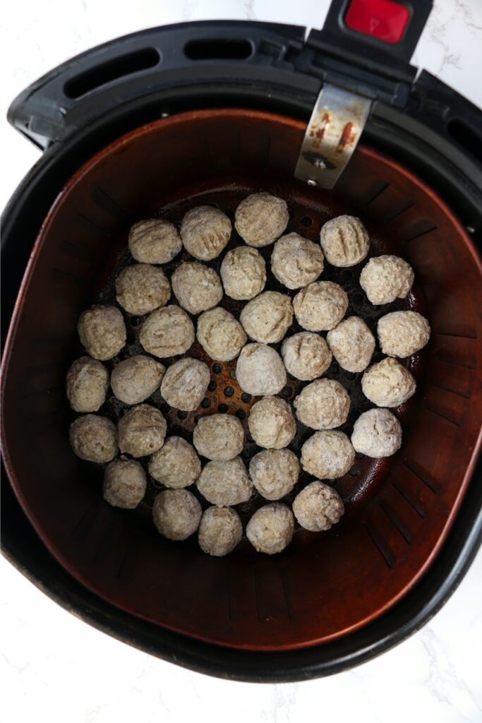 Overhead shot of frozen meatballs in air fryer basket