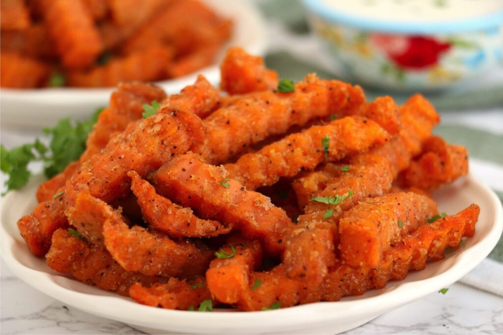 Closeup shot of air fryer frozen sweet potato fries on plate. 