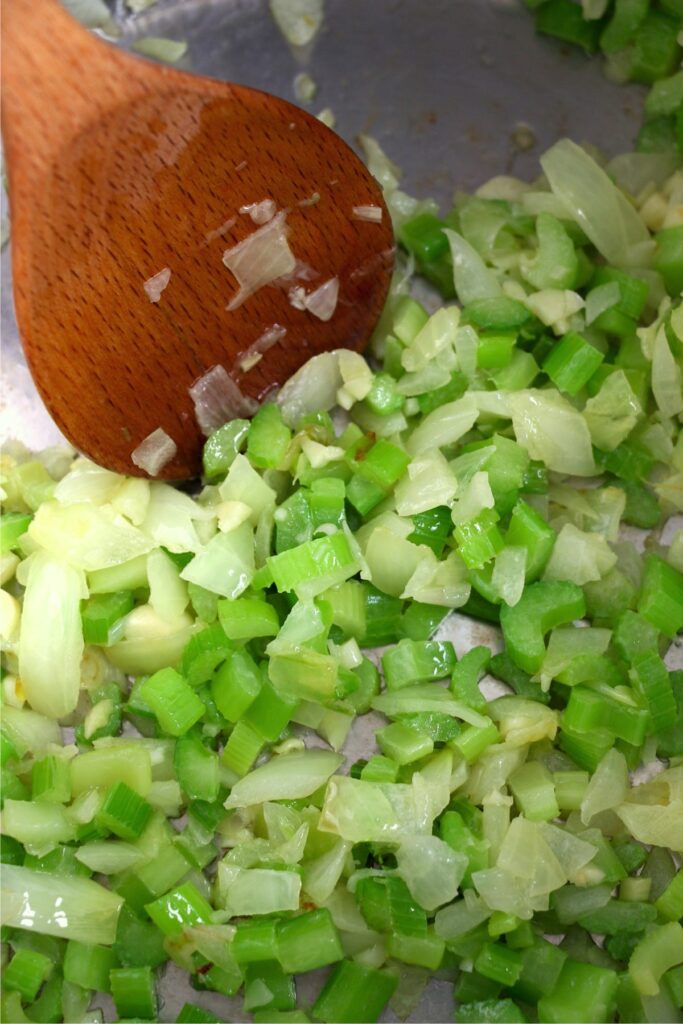 Closeup shot of spoon stirring celery and onions