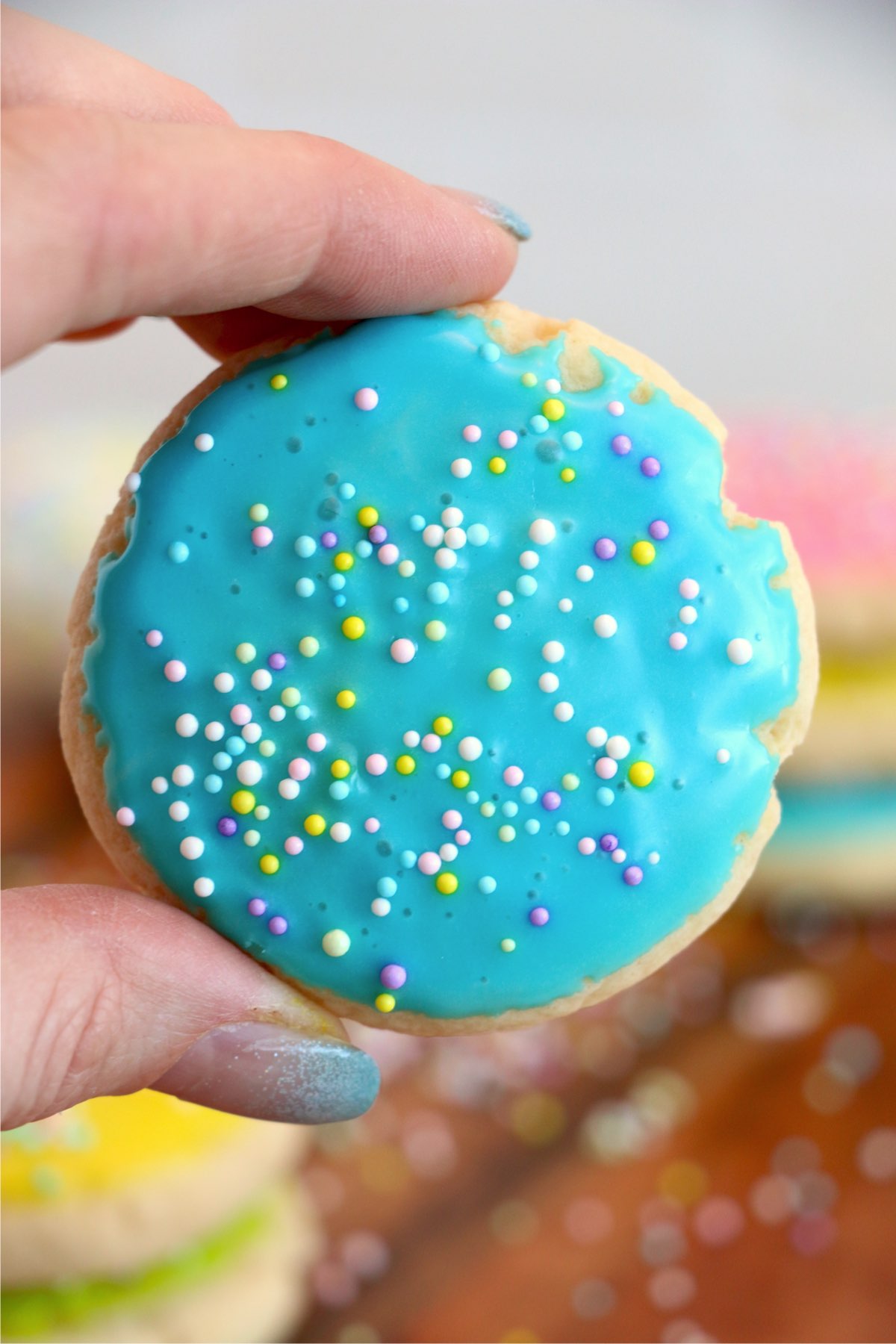 Closeup shot of hand holding iced Easter sugar cookie