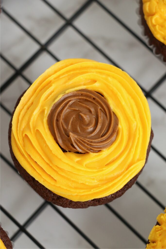 Overhead shot of brown and yellow frosted cupcake