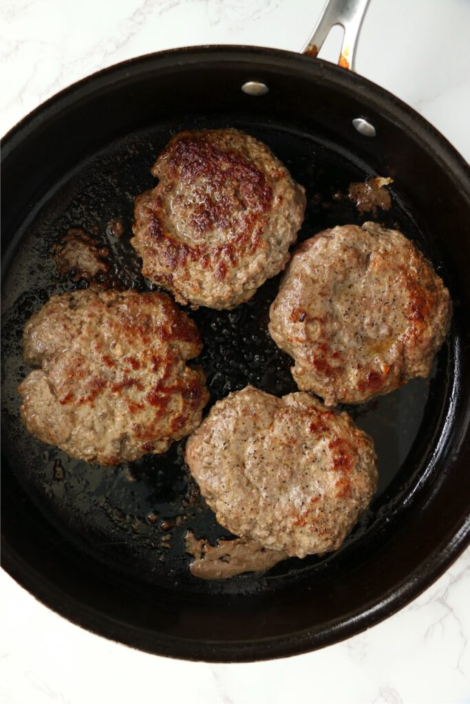 Overhead shot of cooked burgers in skillet