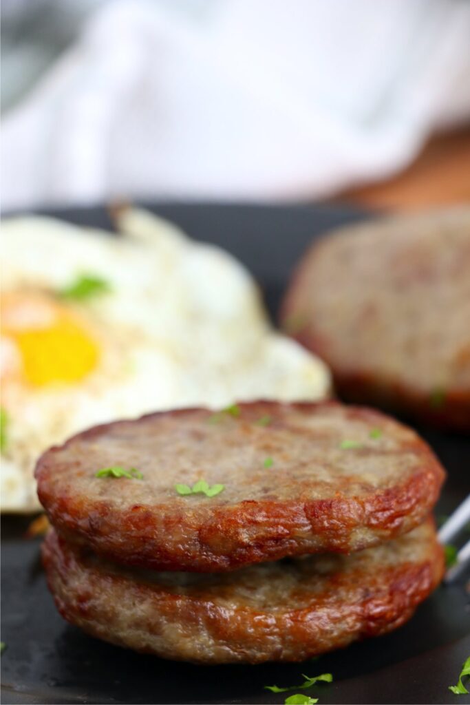 Closeup shot of two air fryer frozen sausage patties stacked atop one another