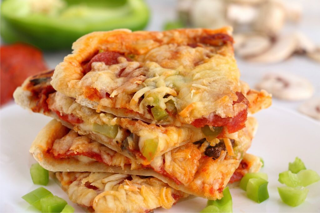 Closeup shot of air fryer pizza slices stacked atop one another on plate