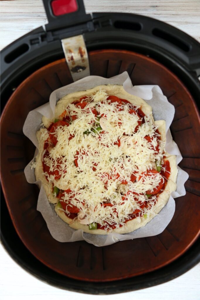 Overhead shot of topped pizza ready to be air fried