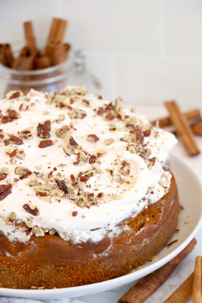 Air fryer pumpkin cake topped with whipped topping on plate