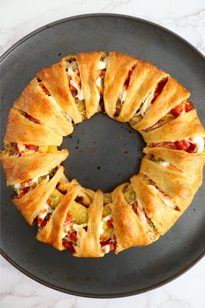 Overhead shot of cooked Taco Bell Crunchwrap Supreme ring on baking pan