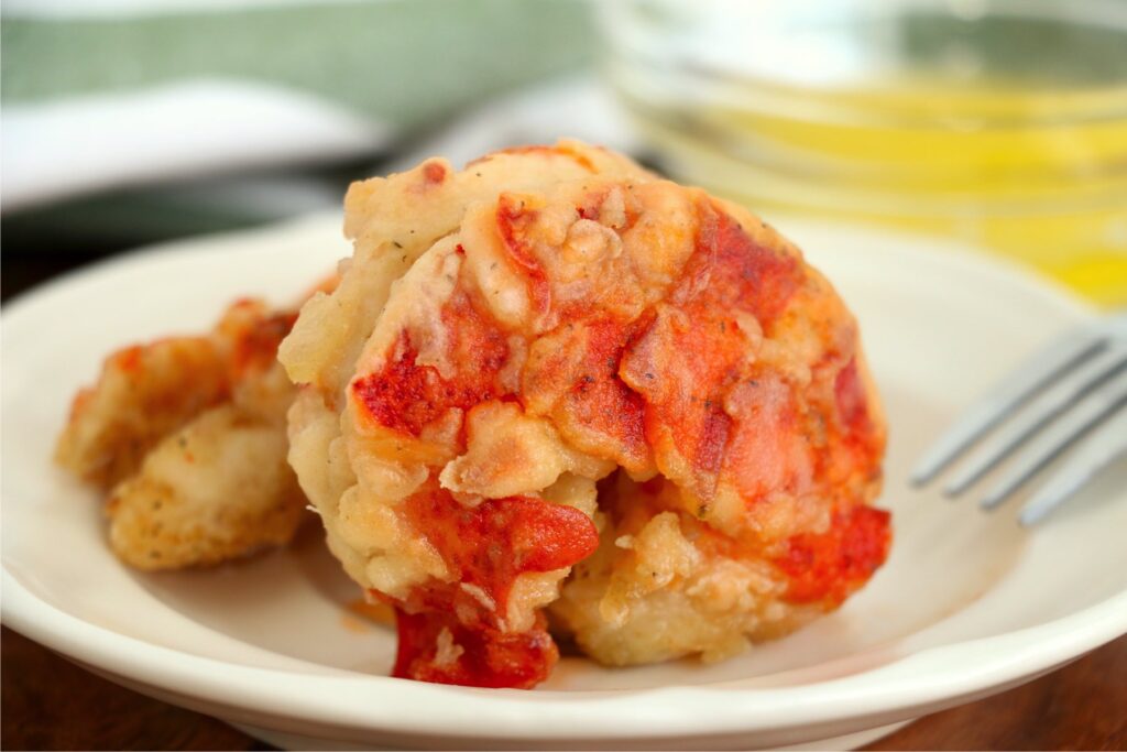 Closeup shot of fried lobster tails on white plate