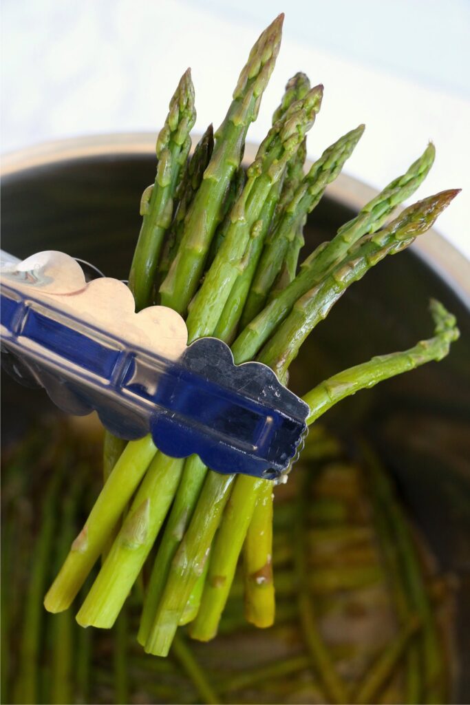 Closeup shot of tongs holding asparagus