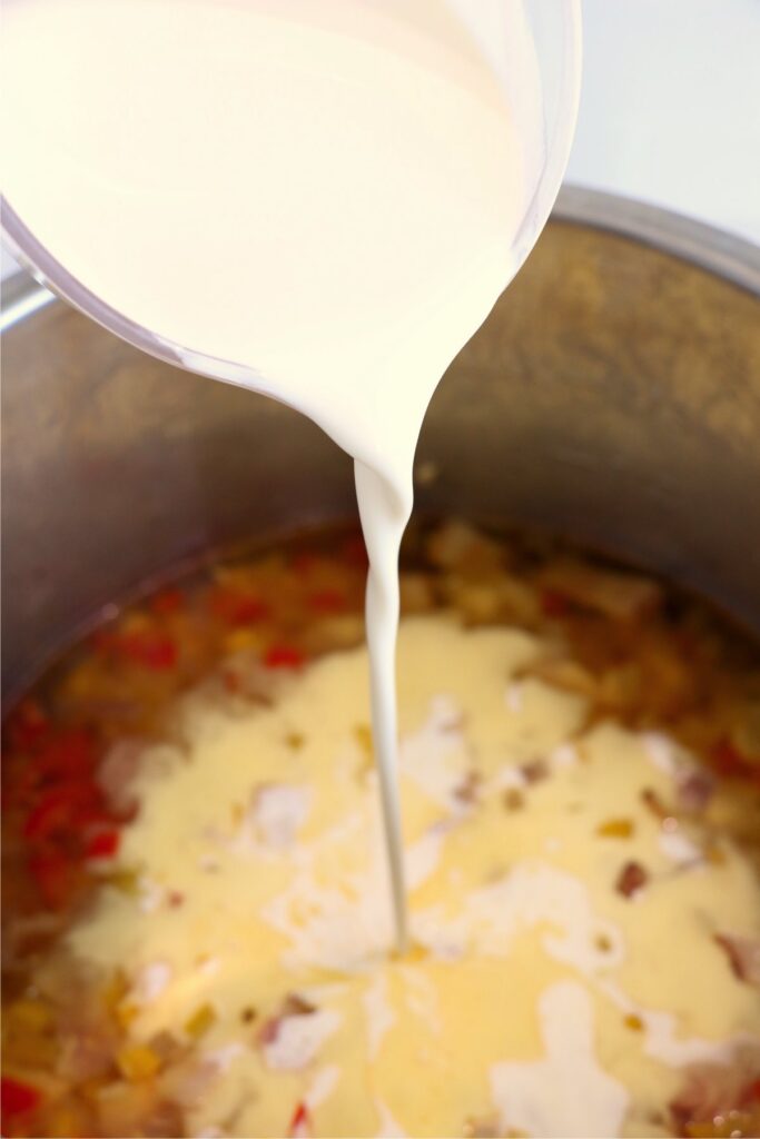 Heavy cream being poured into instant pot chowder 