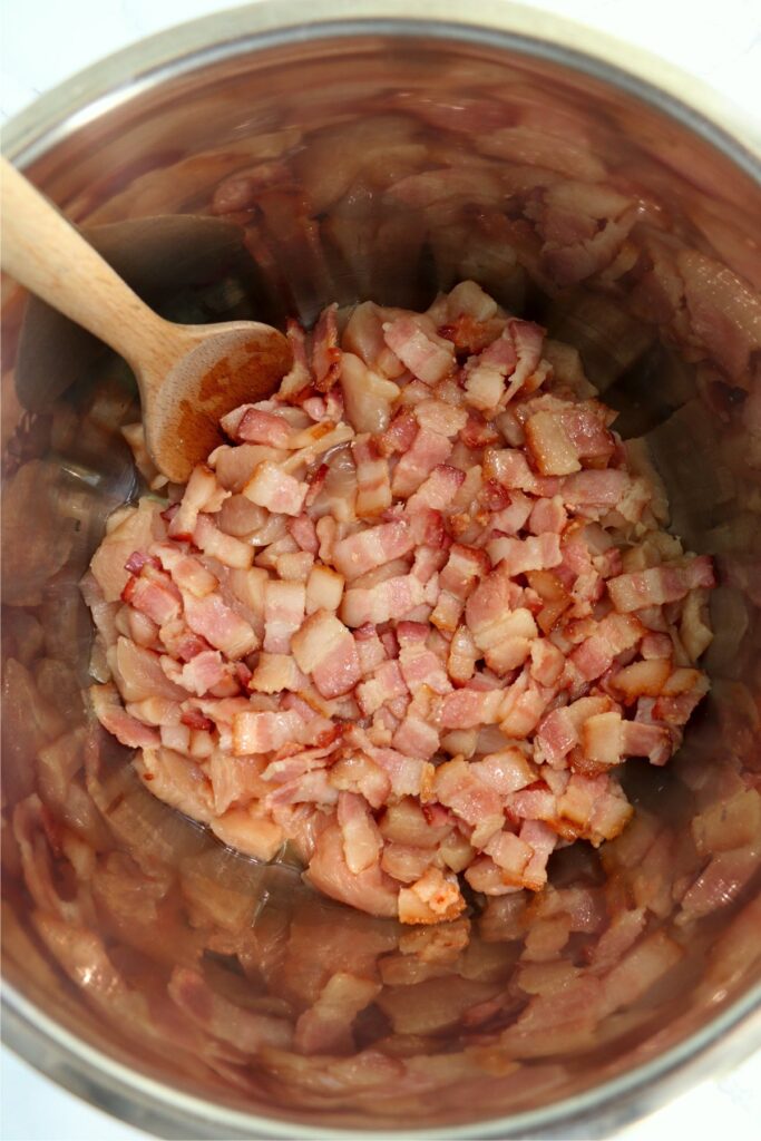 Overhead shot of raw chicken and bacon in instant pot