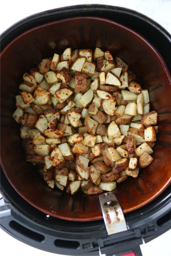 Overhead shot of cooked potatoes in air fryer basket