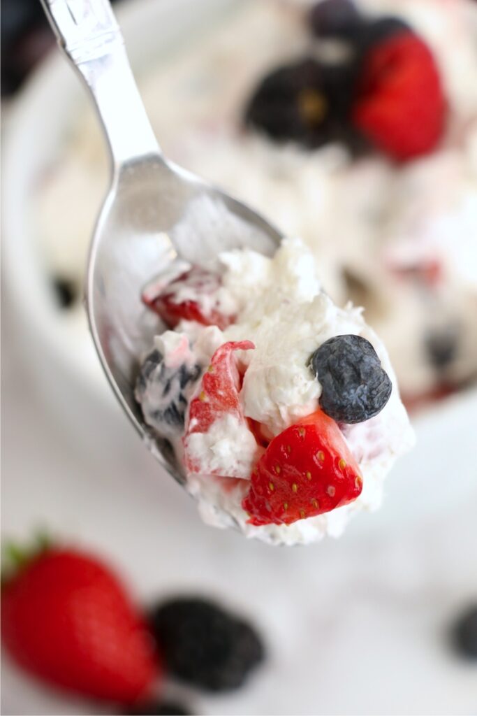 Closeup shot of spoonful of berry cheesecake salad