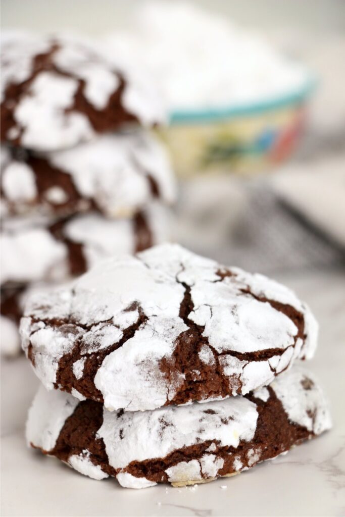 Two chocolat crack cookies stacked atop one another with more cookies in backgroudnd