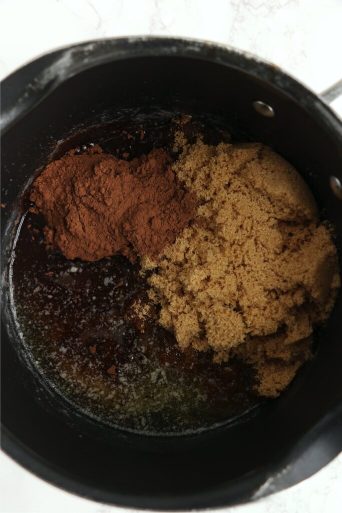 Overhead shot of brown sugar, butter, and cocoa in saucepan