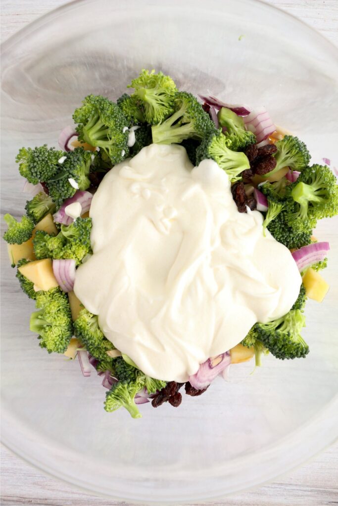 Dressing poured over vegetables and fruit in bowl