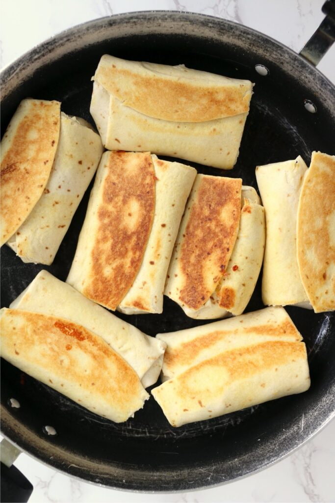 Overhead shot of toasted chicken salad wraps in pan