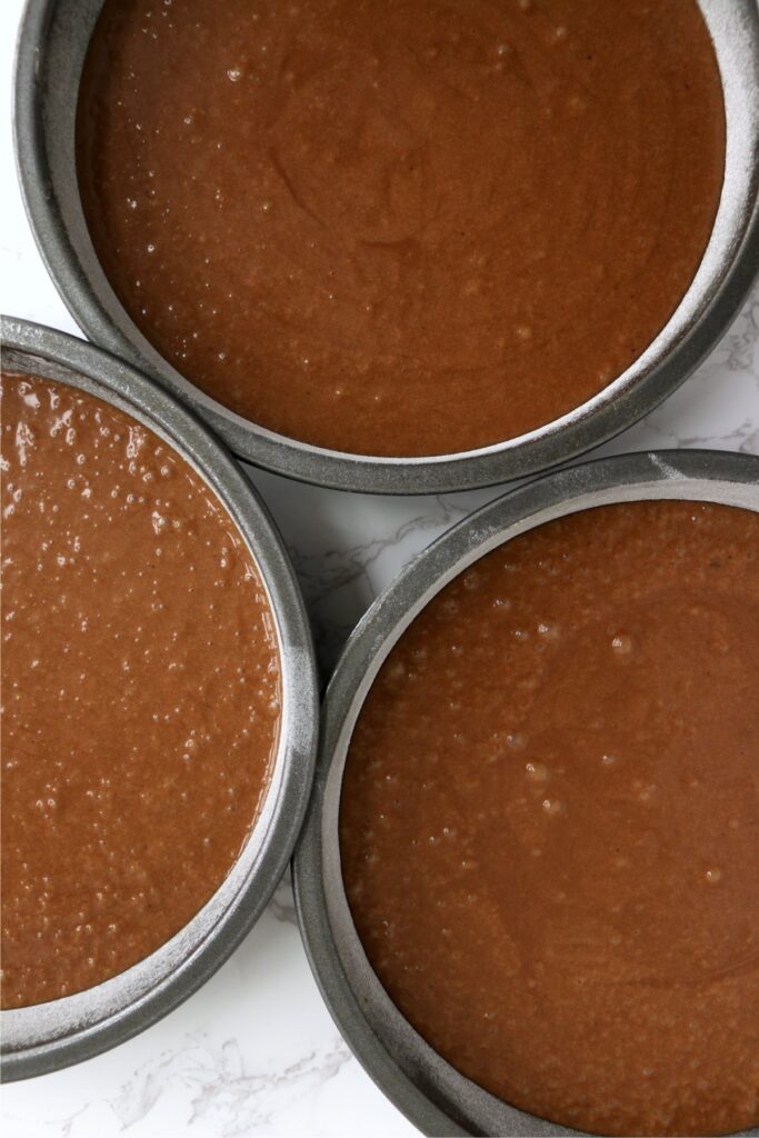 Overhead shot of three round cake pans with batter