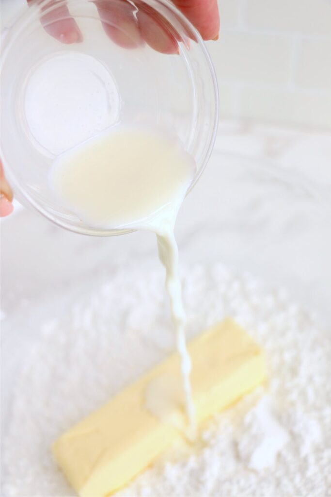 Milk being poured into butter and powdered sugar