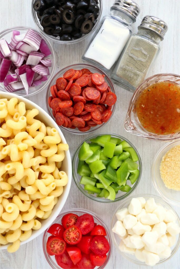 Overhead shot of pasta salad ingredients in individual bowls