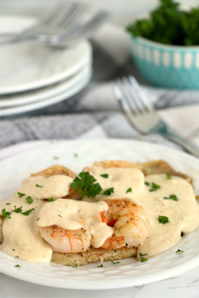 Tilapi and shrimp with sauce on plate