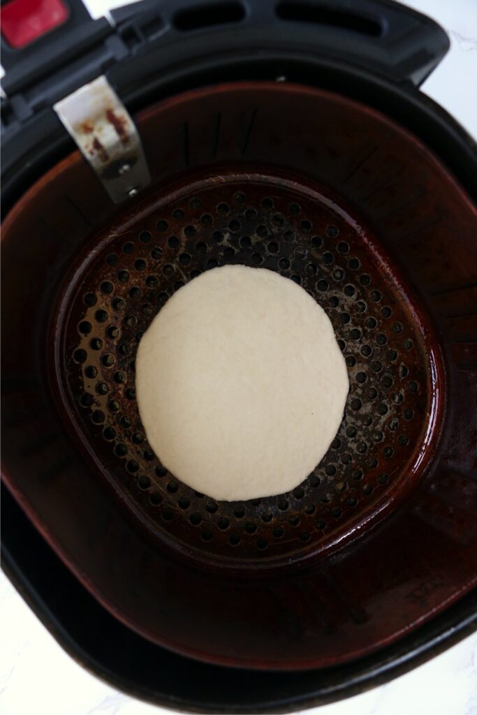 Overhead shot of flatbread dough in air fryer basket