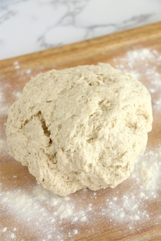 Ball of flatbread dough on floured cutting board