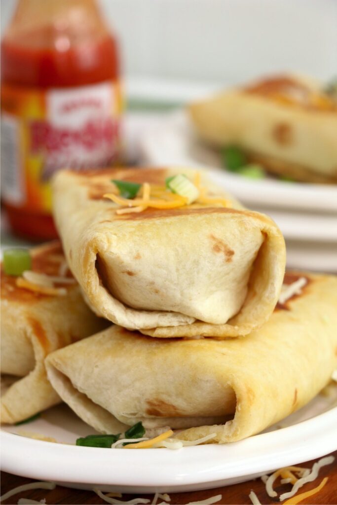 Closeup shot of Buffalo chicken wraps stacked atop one another on plate