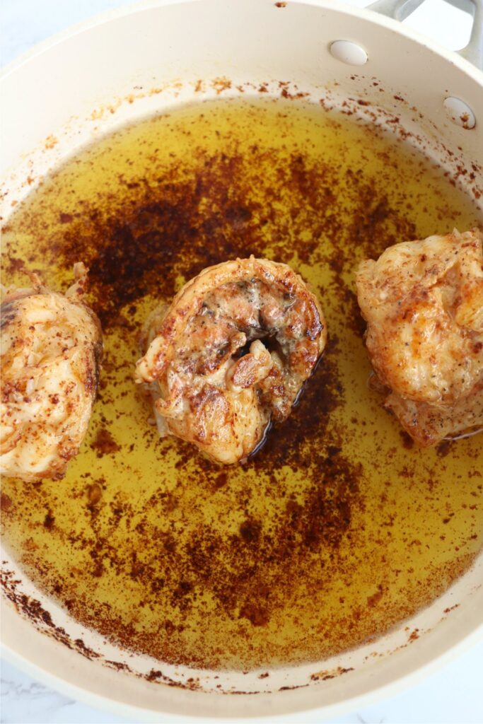 Overhead shot of cooked butter poached lobster tails in pot