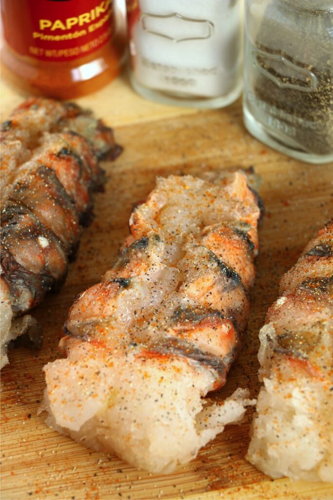 Closeup shot of seasoned lobster tails on cutting board