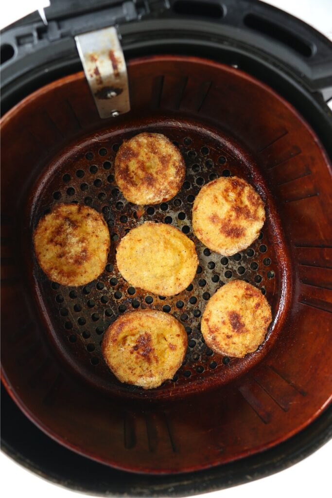 Overhead shot of fried red tomatoes in air fryer basket