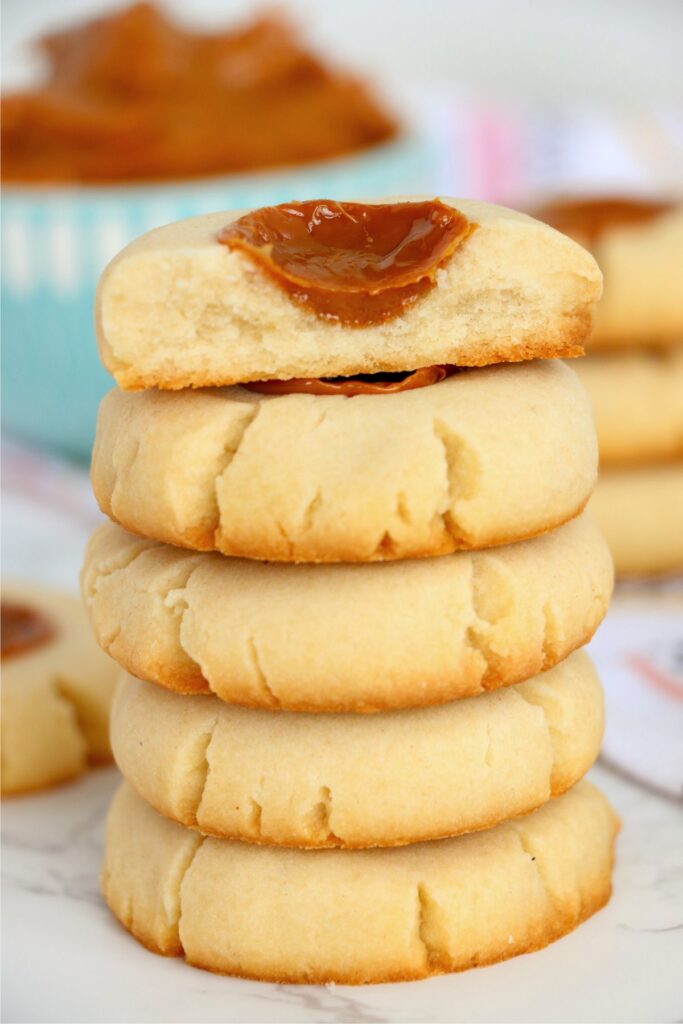 Closeup shot of dulce de leche cookies stacked atop one another with top cookie cut in half