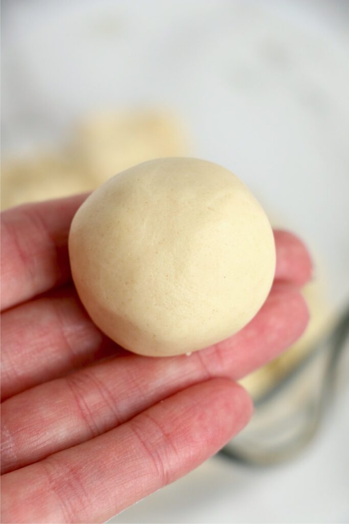 Closeup shot of hand holding ball of cookie dough