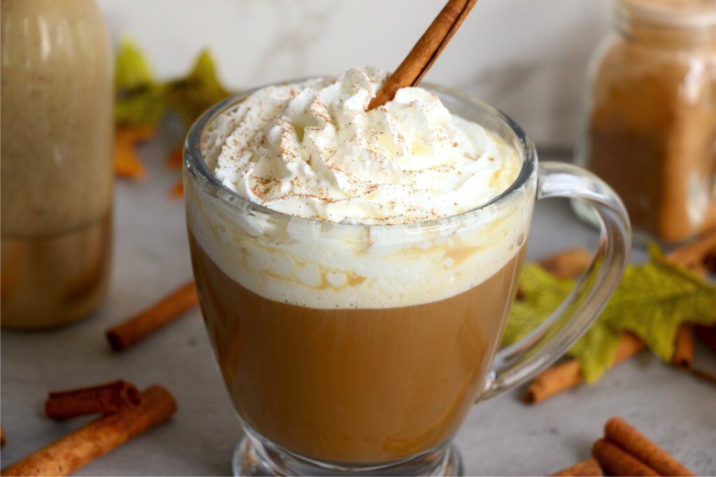 Mug filled with coffee and creamer and topped with whipped cream