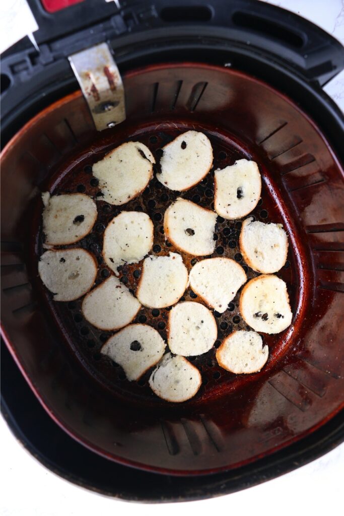 Overhead shot of bagel slices in air fryer basket