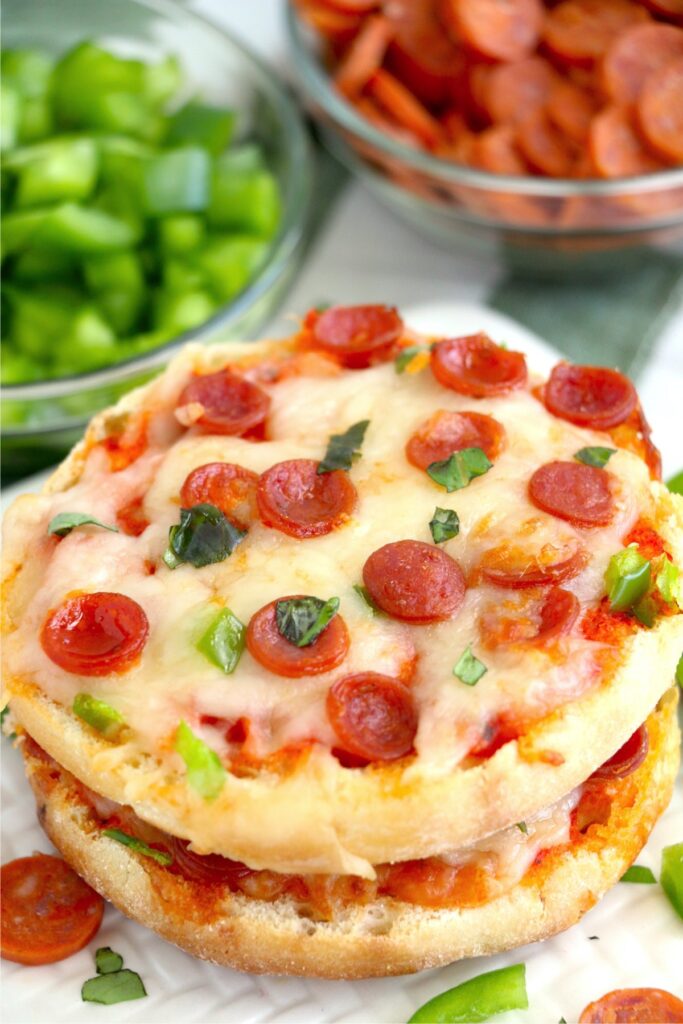 Closeup shot of two air fryer English muffin pizzas stacked atop one another