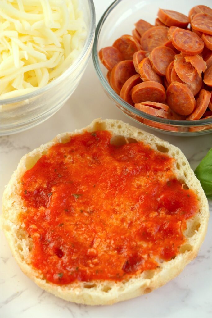 Closeup shot of half an English muffin topped with pizza sauce