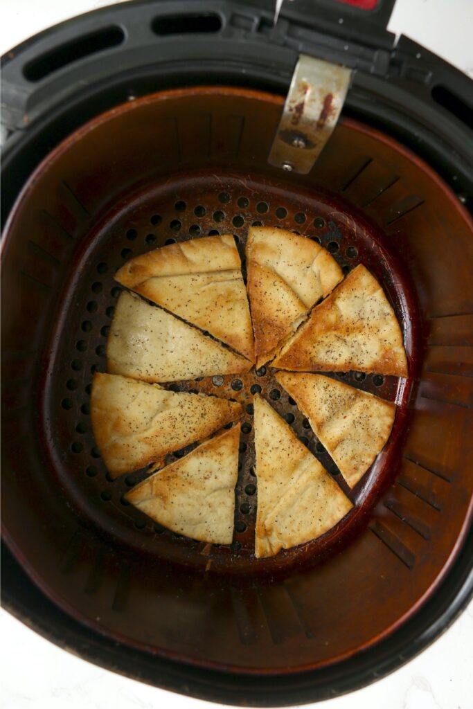 Overhead shot of cooked pita chips in air fryer basket