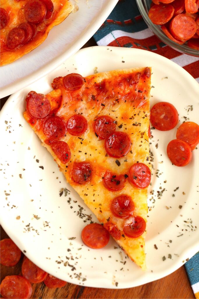 Overhead shot of slice of air fryer tortilla pizza on plate