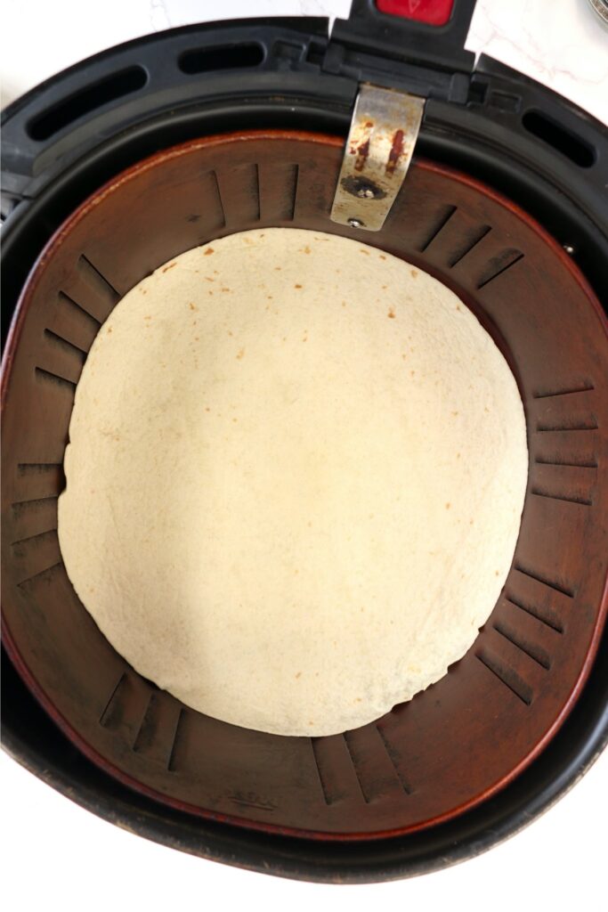 Overhead shot of tortilla in air fryer basket